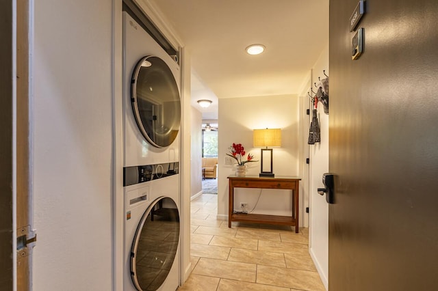 laundry area featuring stacked washing maching and dryer and light tile patterned flooring