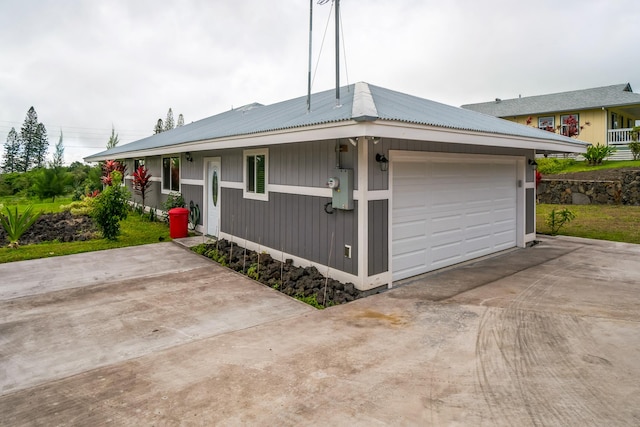 view of front of property featuring metal roof and driveway