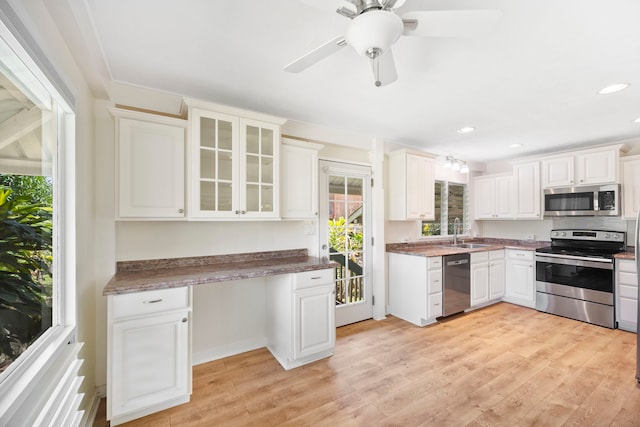 kitchen featuring appliances with stainless steel finishes, white cabinets, and light wood-type flooring