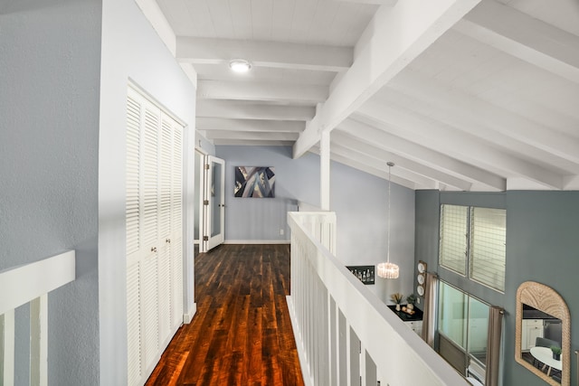 hall featuring wood finished floors, vaulted ceiling with beams, an upstairs landing, and baseboards