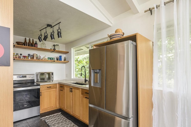 kitchen featuring sink, stainless steel appliances, and a textured ceiling