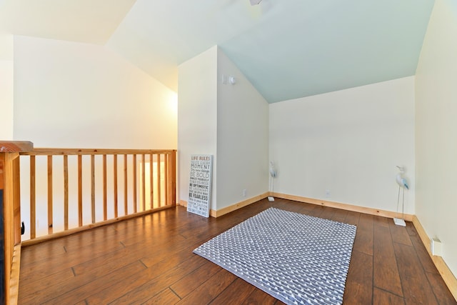 bonus room with dark hardwood / wood-style flooring and vaulted ceiling