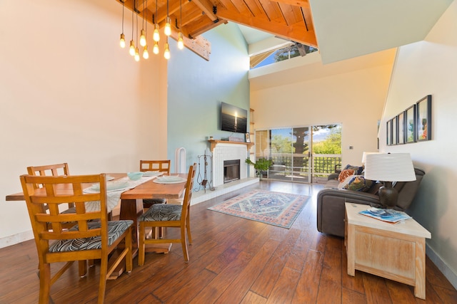 dining area with a high ceiling, dark wood-type flooring, and a fireplace