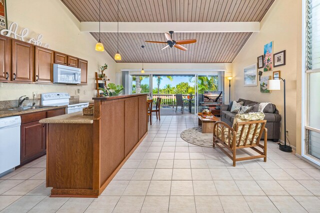 kitchen featuring decorative light fixtures, beamed ceiling, sink, dark stone countertops, and white appliances