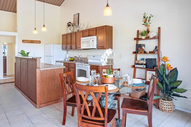 tiled dining area with sink and high vaulted ceiling