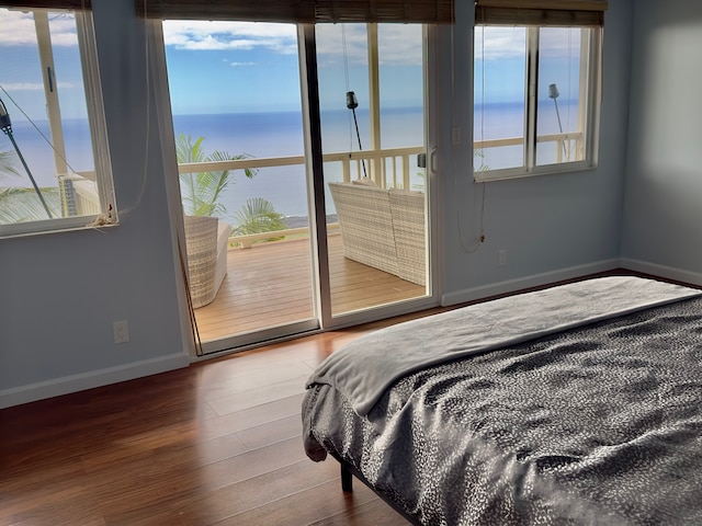 bedroom with a water view, access to exterior, and hardwood / wood-style flooring