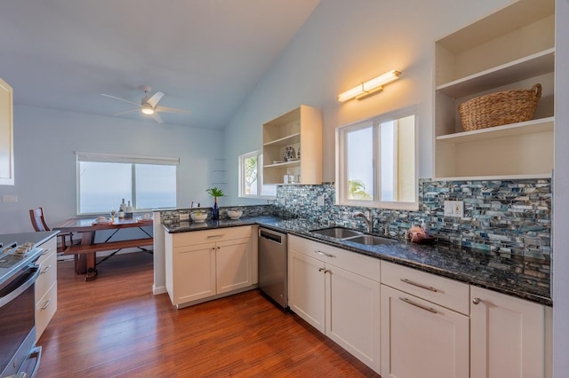 kitchen with dark hardwood / wood-style floors, white cabinetry, sink, dark stone countertops, and stainless steel appliances