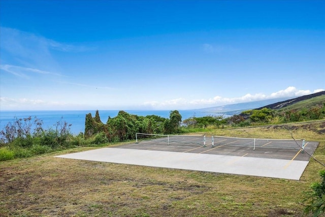 view of property's community with a water view and tennis court