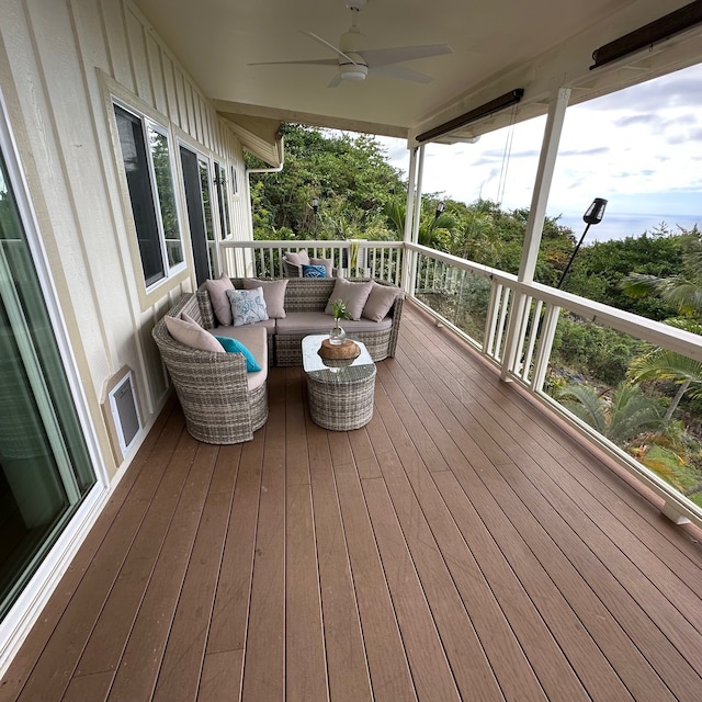 wooden deck with an outdoor living space and ceiling fan