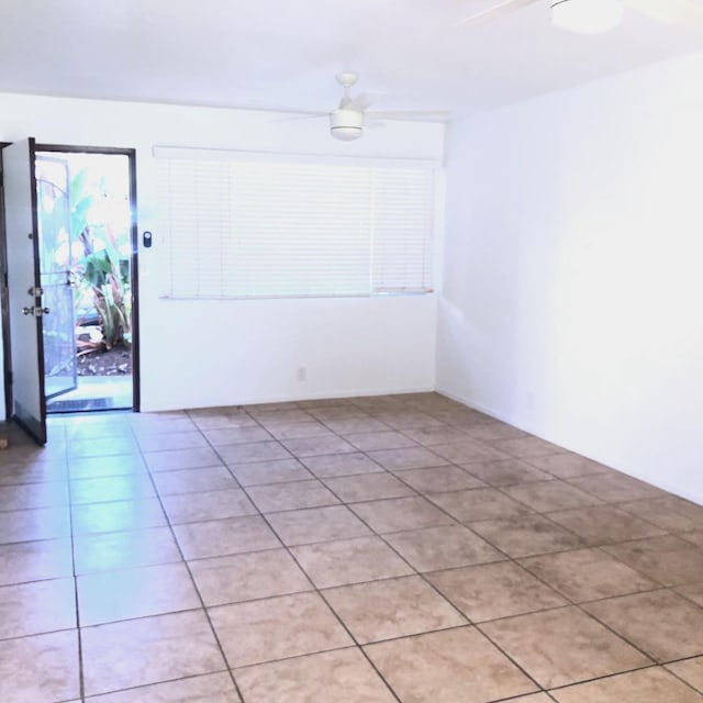 tiled empty room featuring ceiling fan