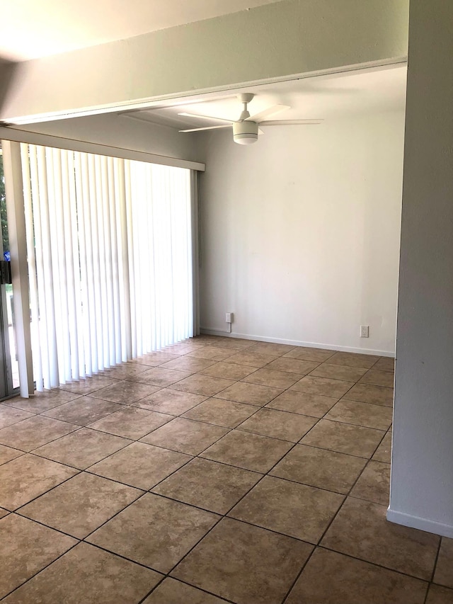 tiled spare room with ceiling fan