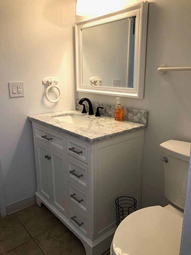 bathroom featuring vanity, tile patterned floors, and toilet