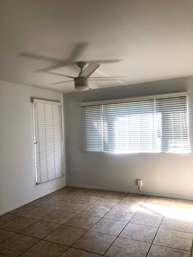 empty room featuring light tile patterned flooring and ceiling fan