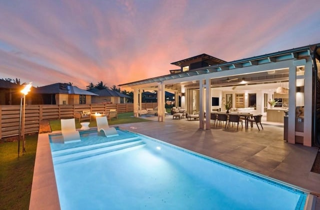 pool at dusk featuring a pergola and a patio area