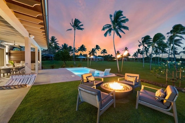 exterior space featuring a lawn, a patio area, and a fire pit