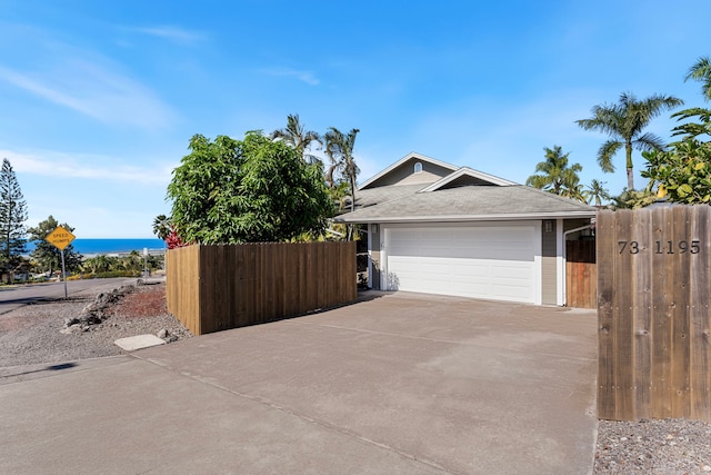 exterior space with a garage and a water view