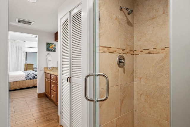 full bathroom with a closet, visible vents, a stall shower, connected bathroom, and wood finished floors