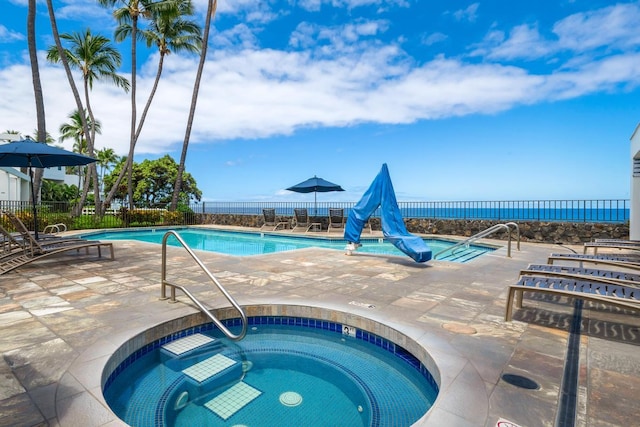 community pool featuring a hot tub, fence, and a patio