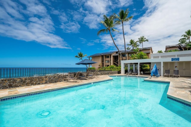 community pool with a patio and a water view