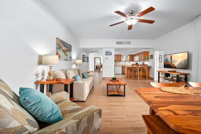 living room featuring ceiling fan, light wood-style flooring, and visible vents