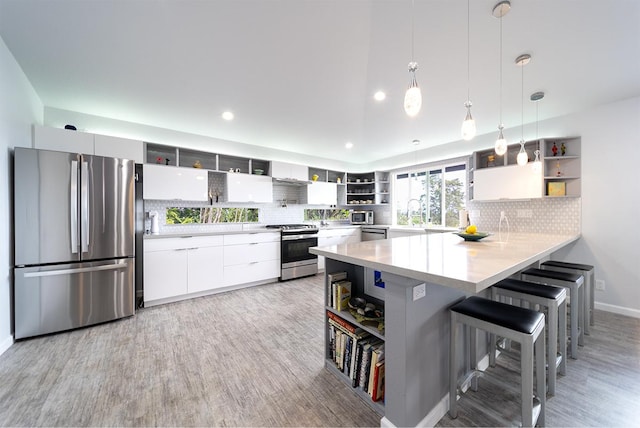 kitchen with stainless steel appliances, a peninsula, and open shelves