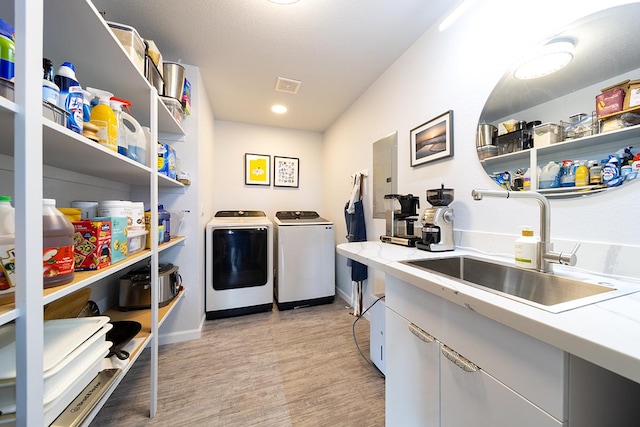 washroom featuring laundry area, visible vents, independent washer and dryer, light wood-type flooring, and a sink