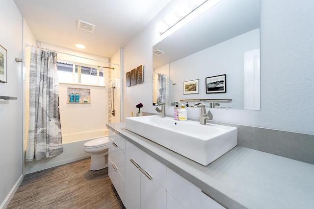 full bath with toilet, shower / tub combo, wood finished floors, vanity, and visible vents