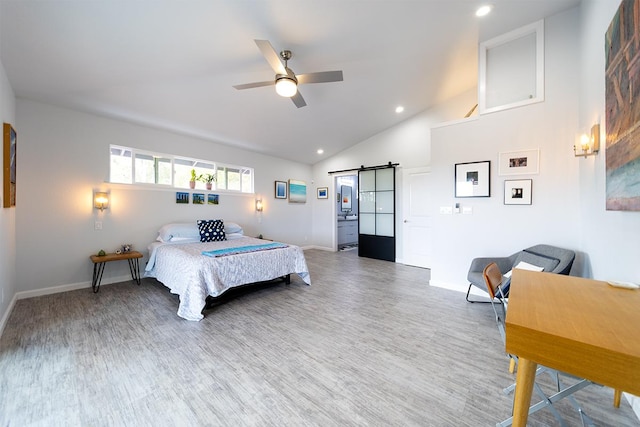 bedroom featuring a barn door, baseboards, wood finished floors, and recessed lighting