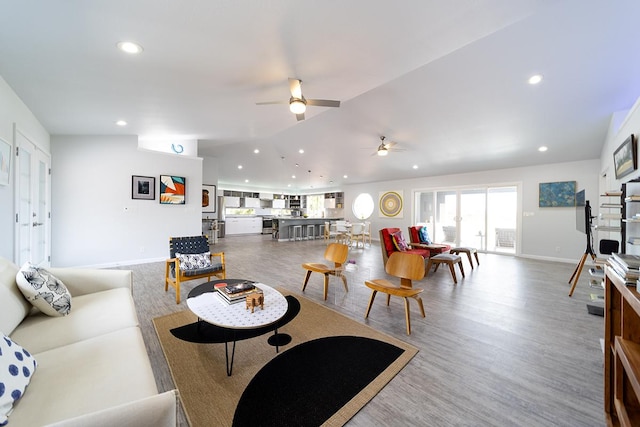 living room with lofted ceiling, baseboards, recessed lighting, and wood finished floors