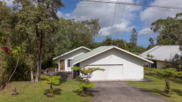 view of front facade featuring an attached garage, a front lawn, and aphalt driveway