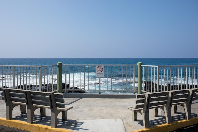 view of patio with a water view and a beach view