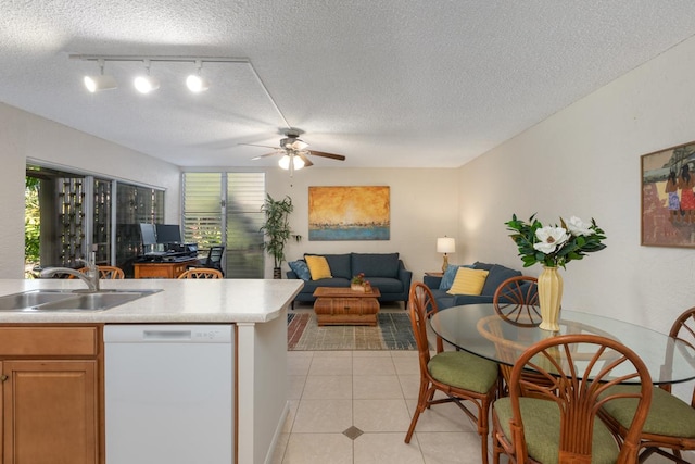 kitchen with light tile patterned flooring, sink, a textured ceiling, white dishwasher, and ceiling fan