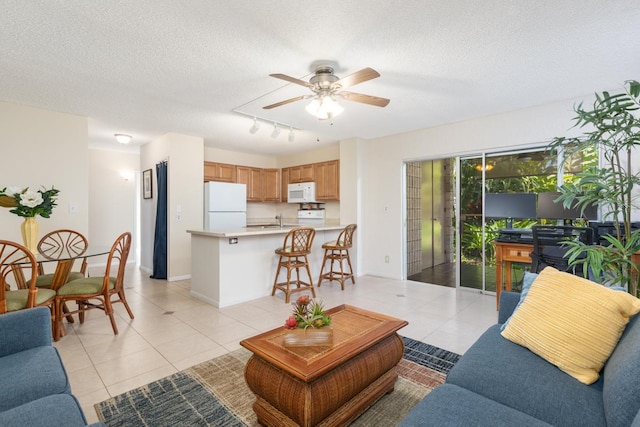 tiled living room featuring ceiling fan, sink, and a textured ceiling