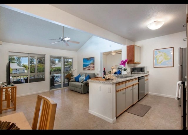 kitchen featuring a ceiling fan, a peninsula, a sink, stainless steel appliances, and light countertops