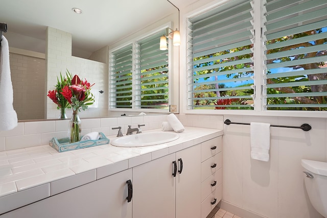 bathroom with vanity, toilet, and decorative backsplash