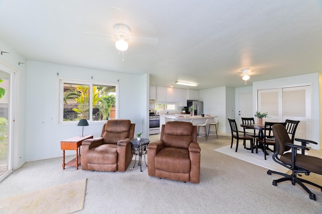 living room featuring a ceiling fan and light colored carpet