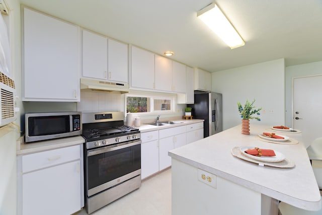 kitchen featuring a sink, light countertops, appliances with stainless steel finishes, under cabinet range hood, and a center island