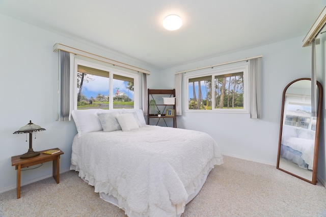 bedroom with baseboards and light carpet