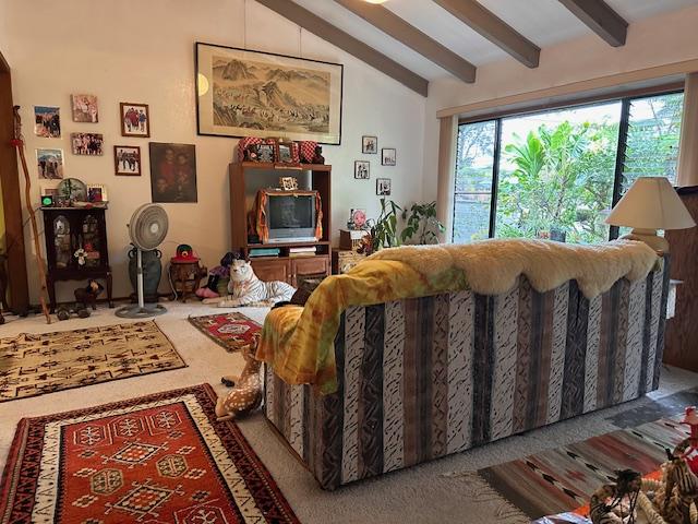 living room featuring carpet floors and lofted ceiling with beams