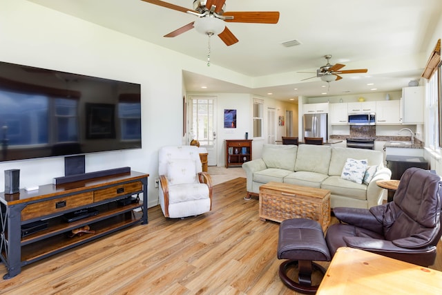 living room featuring a ceiling fan, recessed lighting, visible vents, and light wood-style flooring