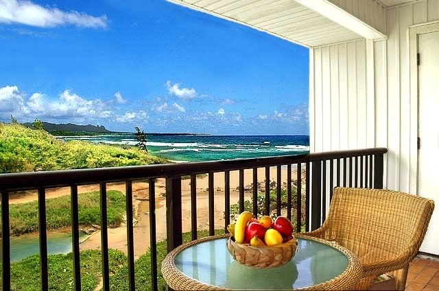 balcony with a water view and a view of the beach