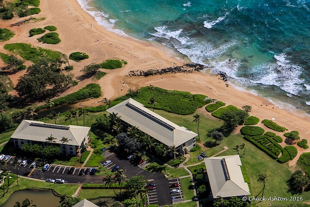 birds eye view of property with a water view and a beach view