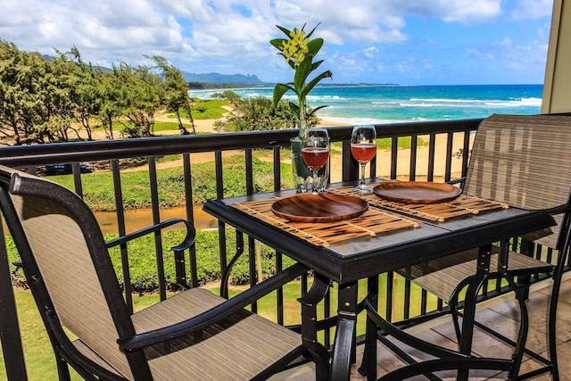 balcony featuring a water view and a beach view