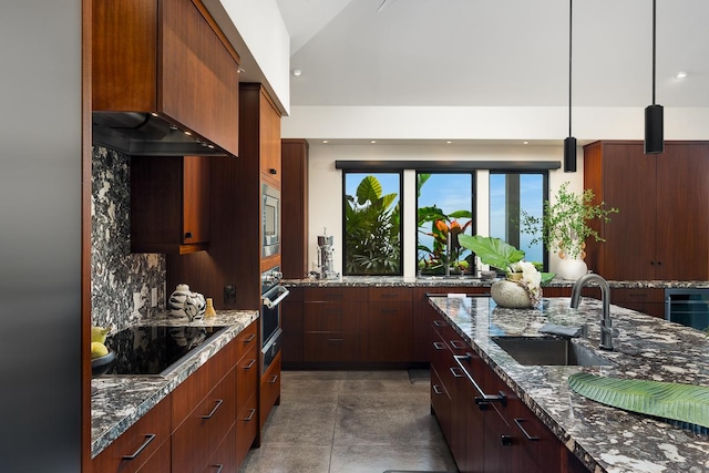 kitchen with appliances with stainless steel finishes, sink, pendant lighting, dark stone counters, and decorative backsplash