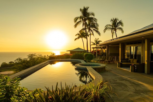 exterior space with a water view, a patio area, and a pool with connected hot tub