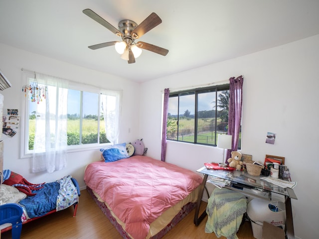 bedroom featuring ceiling fan, baseboards, and wood finished floors