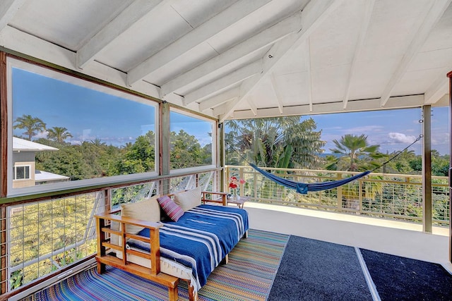 sunroom / solarium featuring beam ceiling and plenty of natural light