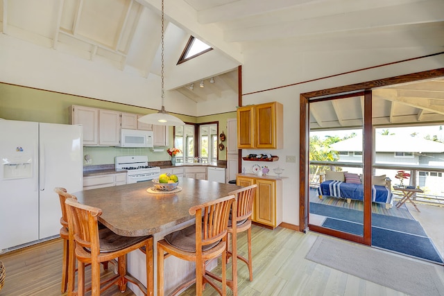 kitchen featuring decorative light fixtures, high vaulted ceiling, light wood-type flooring, beamed ceiling, and white appliances