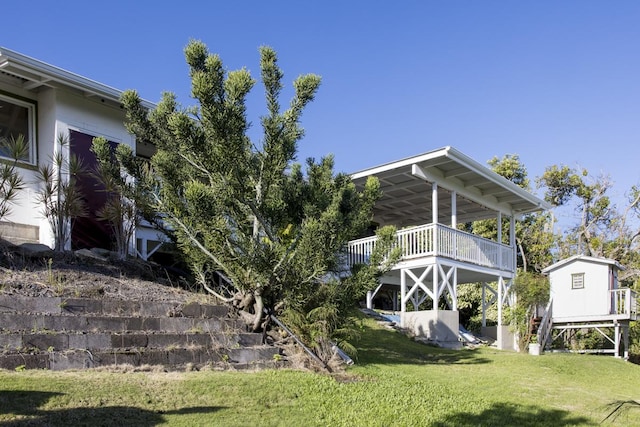 rear view of property with a wooden deck and a lawn