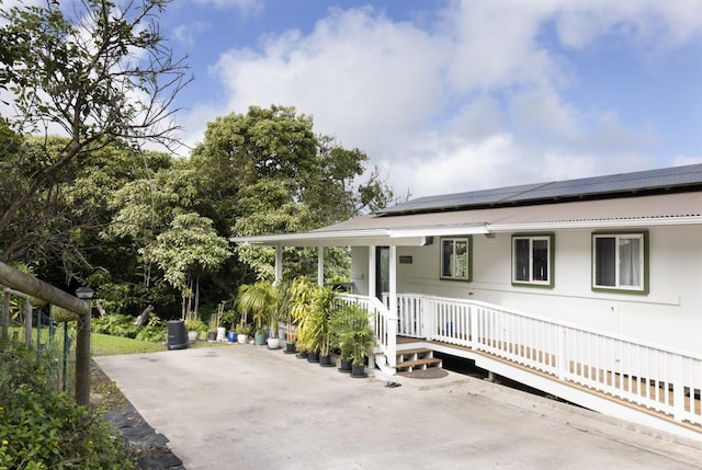 view of front of home with a patio area and solar panels